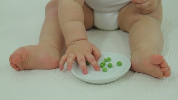 Bebé comiendo guisantes verdes — Vídeo de stock