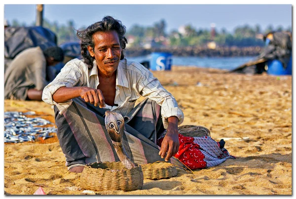 Charmer serpente mostrar suas habilidades com uma cobra para turistas na praia no Sri Lanka — Fotografia de Stock