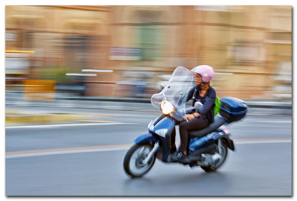 Женщина избавляется от мотоцикла на улицах Пизы Италия — стоковое фото