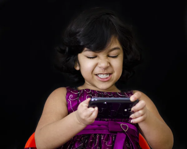 En söt tjej som spelar spel på mobilen — Stockfoto