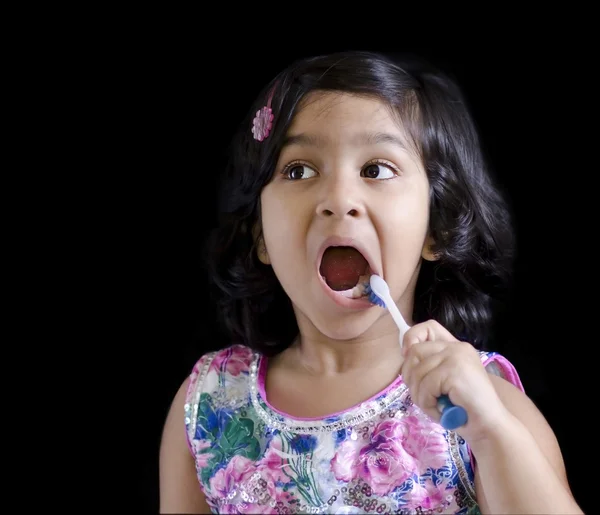 Uma menina está escovando os dentes — Fotografia de Stock