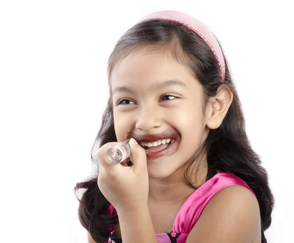 Ein kleines Mädchen spielt mit einem Lippenstift — Stockfoto