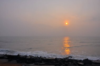 Okyanus manzaralı güzel bir gün doğumu ve Pondicherry, Tamil Nadu, Hindistan 'da kayalık bir plaj.