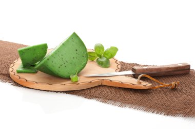 kahverengi kesme tahtası üzerinde yeşil gouda peyniri.