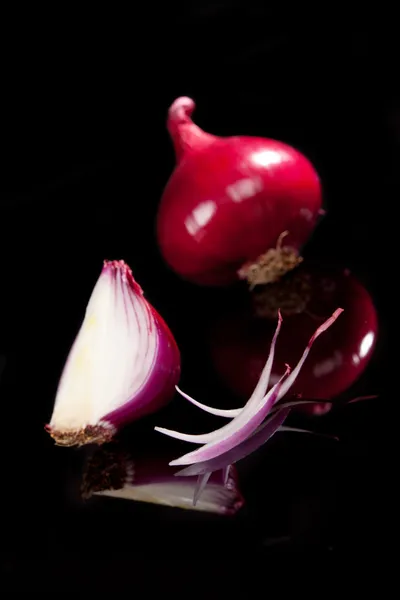 Fialové cibule na černém pozadí. cibule pozadí. — Stock fotografie