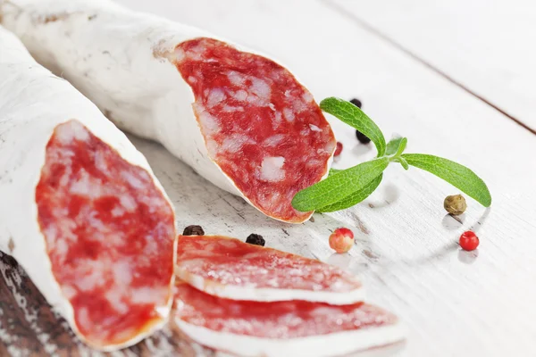 Salsicce fuet culinarie con grani di pepe colorati . — Foto Stock