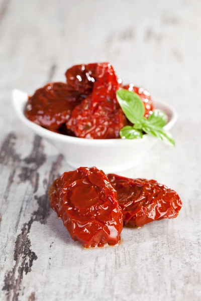 Dried tomatoes with basil leaves. — Stock Photo, Image