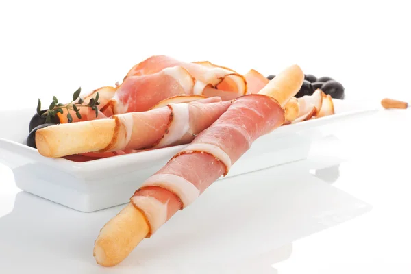 Fondo culinario de la comida. Prosciutto, pan, aceitunas negras . — Foto de Stock