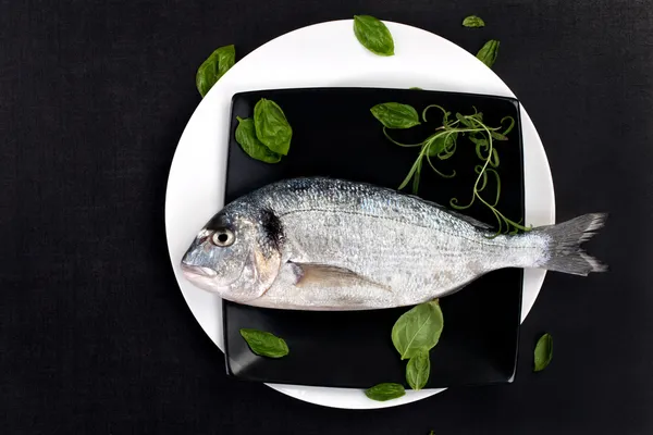 Fish on plate with fresh herbs, top view. — Stock Photo, Image