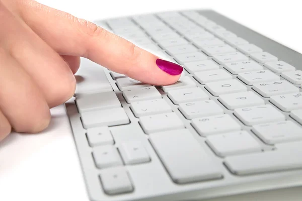 Primer plano de la mano femenina tocando un teclado de metal blanco . — Foto de Stock