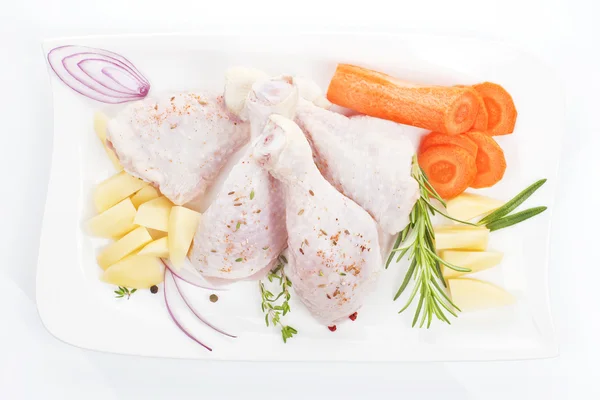 Hühnerkeulen mit Gemüse auf weißem Tablett. — Stockfoto