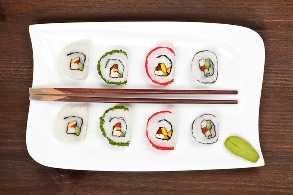 Maki sushi på hvit tallerken med spisepinner . – stockfoto