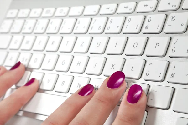 Primer plano de la mano femenina tocando un teclado de metal blanco . — Foto de Stock