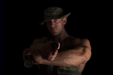 Soldier holding gun and flashlight. clipart