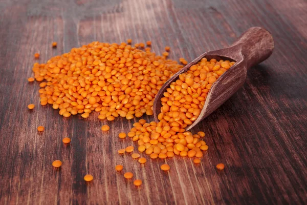 Lentilhas vermelhas em colher de madeira . — Fotografia de Stock