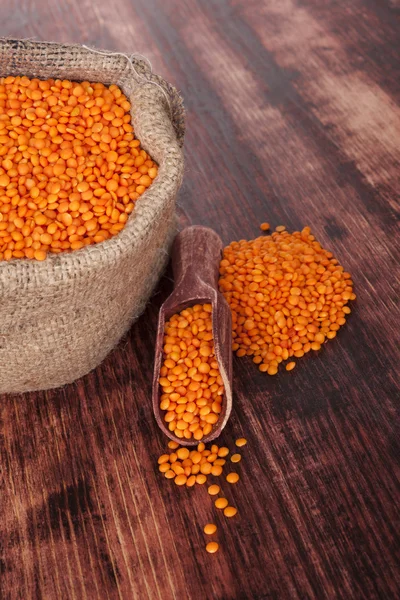 Red lentils on dark wooden background. — Stock Photo, Image