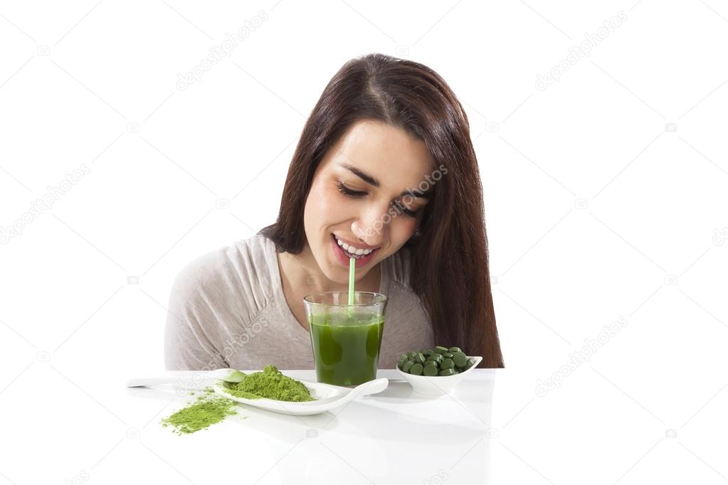 Beautiful girl drinking green juice.