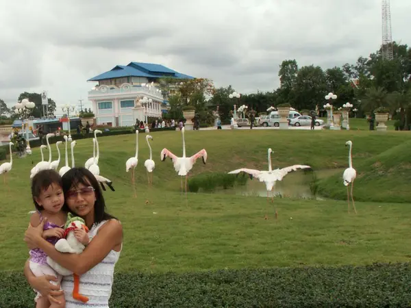 Donna e bambina in giardino con modello di flamingo — Foto Stock