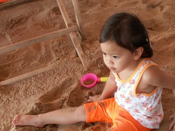 Menina jogando sozinho na areia — Fotografia de Stock