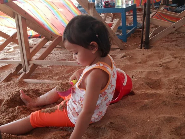 Menina jogando sozinho na areia — Fotografia de Stock