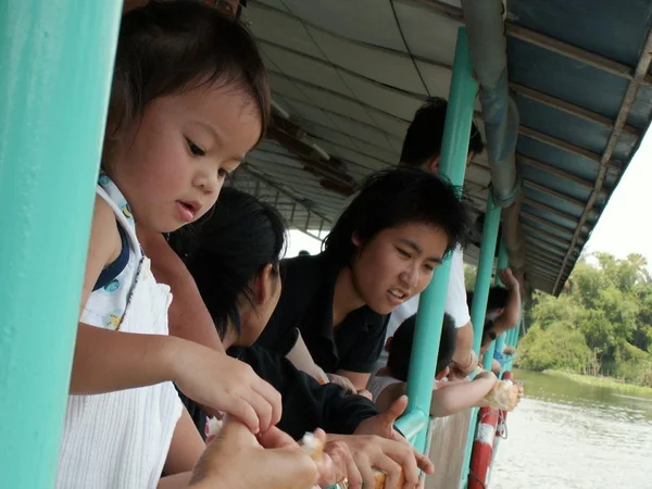 Bambina, alimentazione pane per i pesci nel fiume chao phraya, bangkok Thailandia — Foto Stock