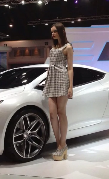 Um carro esporte branco com modelo não identificado de mulher no vestido branco — Fotografia de Stock