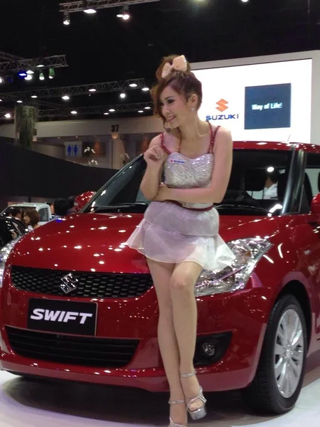 Una suzuki rojo con modelo no identificada en vestido blanco — Foto de Stock