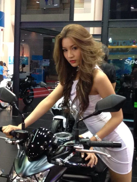 A motorcycle with woman unidentified model on white dress 로열티 프리 스톡 사진