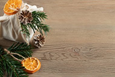 Sıfır israf noeli konsepti. Doğal kumaş hediyeleri ve doğal malzemelerin süsleriyle ahşap masa, üst manzara, kopyalama alanı.