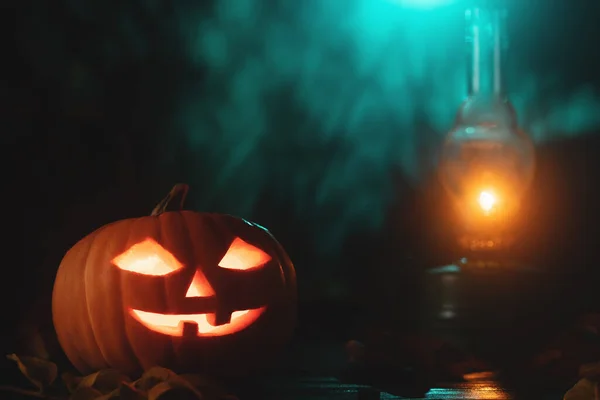 Хэллоуин тыква голова Джек фонарь с светящимися глазами и керосиновой лампой на деревянном столе — стоковое фото
