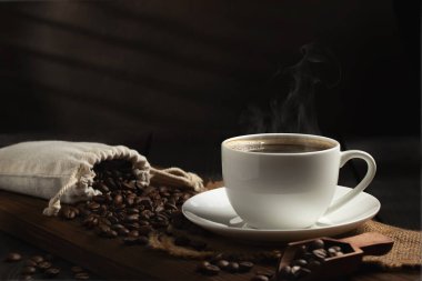 Masadaki tahtanın üzerinde beyaz kahve ve kahve çekirdeği.