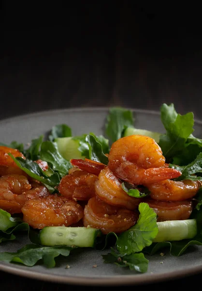 Friss saláta grillezett garnélarákkal, uborkával és arugulával, tányéron tálalva, függőleges képben — Stock Fotó