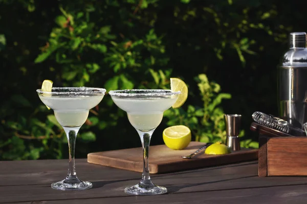 Zwei Gläser mit frischem, hausgemachtem Margarita-Cocktail auf einem Holztisch an einem Sommerabend im Innenhof, selektiver Fokus — Stockfoto