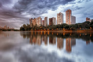 Brezilya 'nın Londrina kentindeki Igapo Gölü manzarası ve arka planda modern binalar.