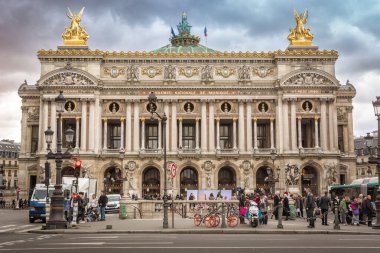Palais Garnier ve Ulusal Müzik Akademisi Paris 'te turistlerle. Neobarok stilinde inşa edilen tiyatro, 16. Louis tarafından 1669 yılında kurulduğundan beri Paris Operası 'na ev sahipliği yapan 13. tiyatrodur..