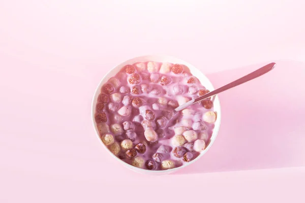 ピンクの背景にシリアルボール ミルクまたはヨーグルトとチョコレートバニラの朝食のボウル ヘルシーなドライクリスピーコーンボール — ストック写真