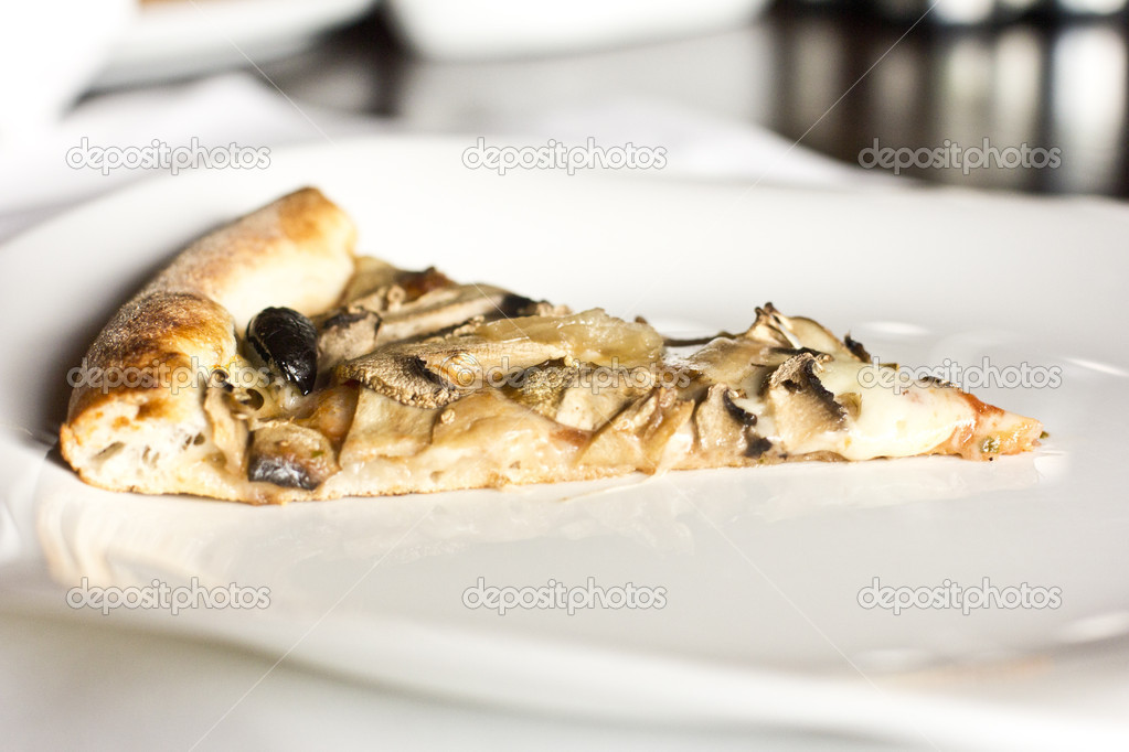 Slice of delicious pizza with mushrooms on a white plate