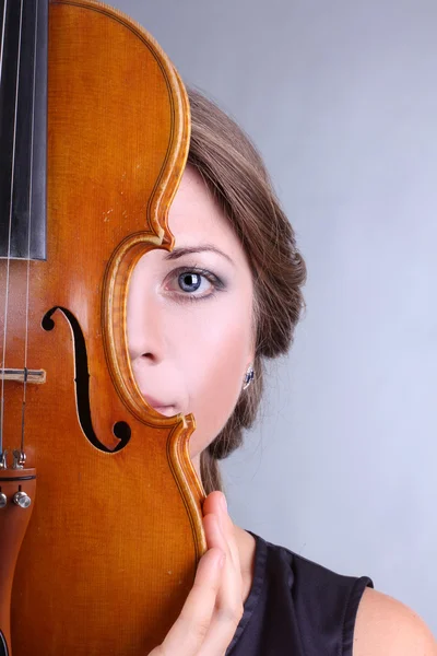 Krásná a jemná dívka drží housle na šedém pozadí — Stockfoto