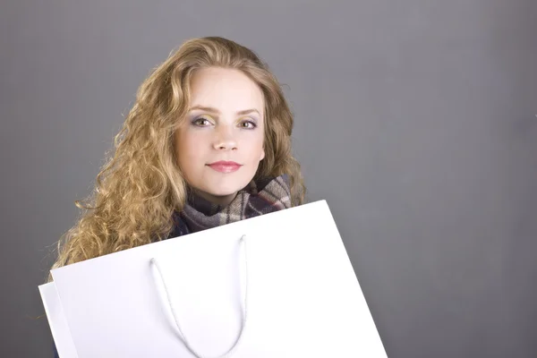 Beautiful curly blonde with a languid sight in the blue coat on gray background — Stock Photo, Image