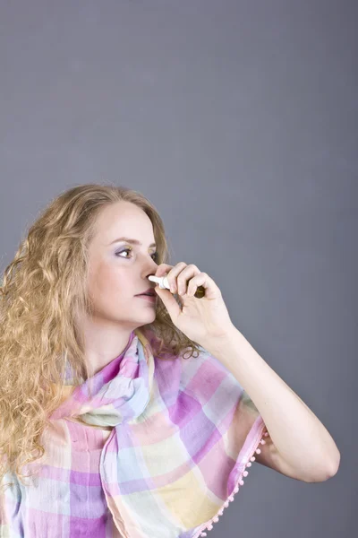 Schönes Mädchen mit weißem lockigem Haar, das Pillen auf grauem Hintergrund hält — Stockfoto