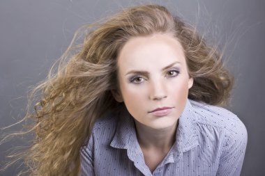 gri arka plan üzerinde güzel makyajlı çekici sarışın