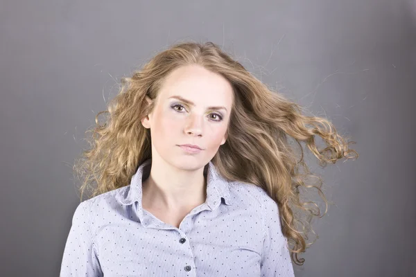 Charmante Blondine mit schönem Make-up auf grauem Hintergrund — Stockfoto