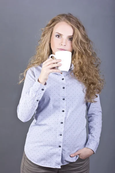 Lovely blonde with curly hair drinking tea or coffee from a white mug — Stock Photo, Image