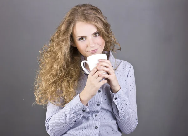 Śliczną blondynką z kręconymi włosami picia kawy lub herbaty z białym kubku — Zdjęcie stockowe