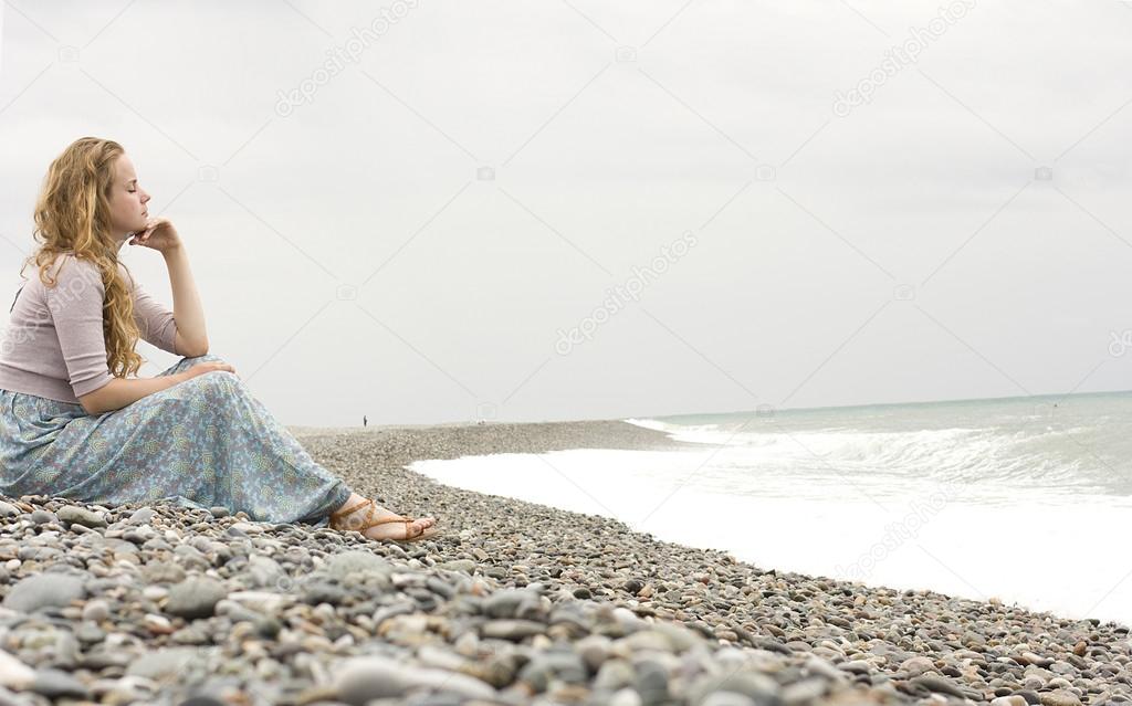 The beautiful blonde with curly hair on the beach. country style