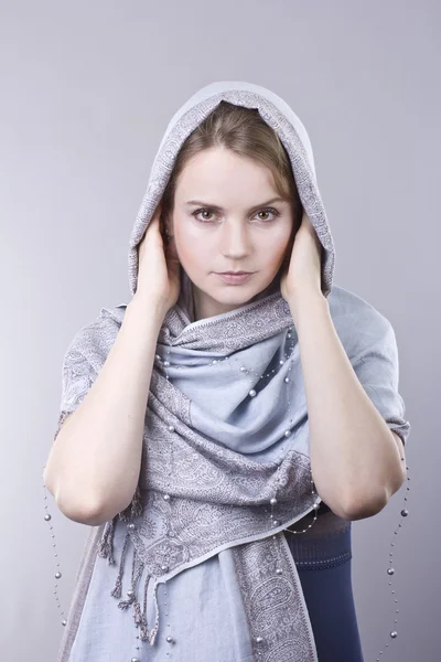 stock image Lovely young blonde in a pale blue scarf on her head on gray background