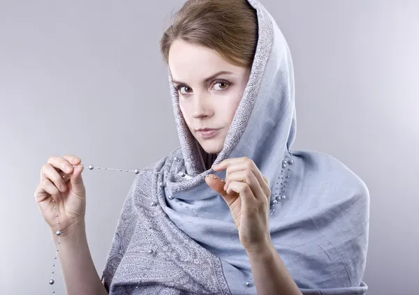 Lovely young blonde in a pale blue scarf on her head on gray background — Stock Photo, Image