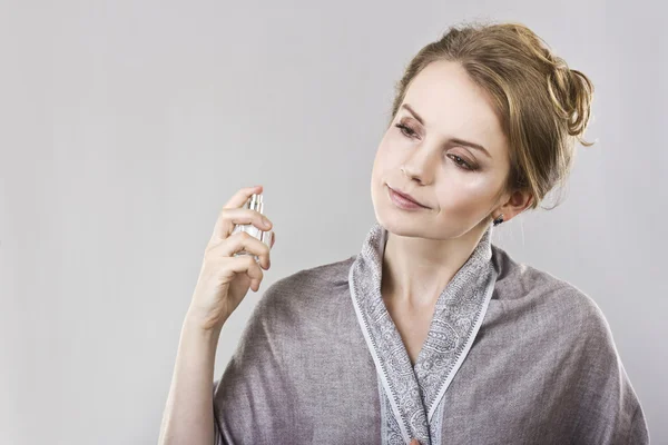 Menina bonita pulveriza o perfume em si mesma — Fotografia de Stock