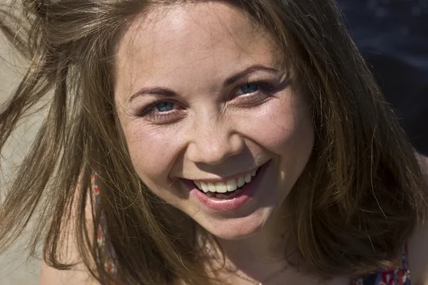 Hermosa joven tomando el sol cerca del agua — Foto de Stock