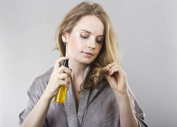Beautiful curly blonde takes care of her hair — Stock Photo, Image
